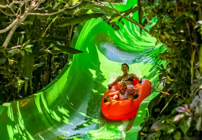 Mom and child on an aquatic slide from a themed photo park The Bali Bible